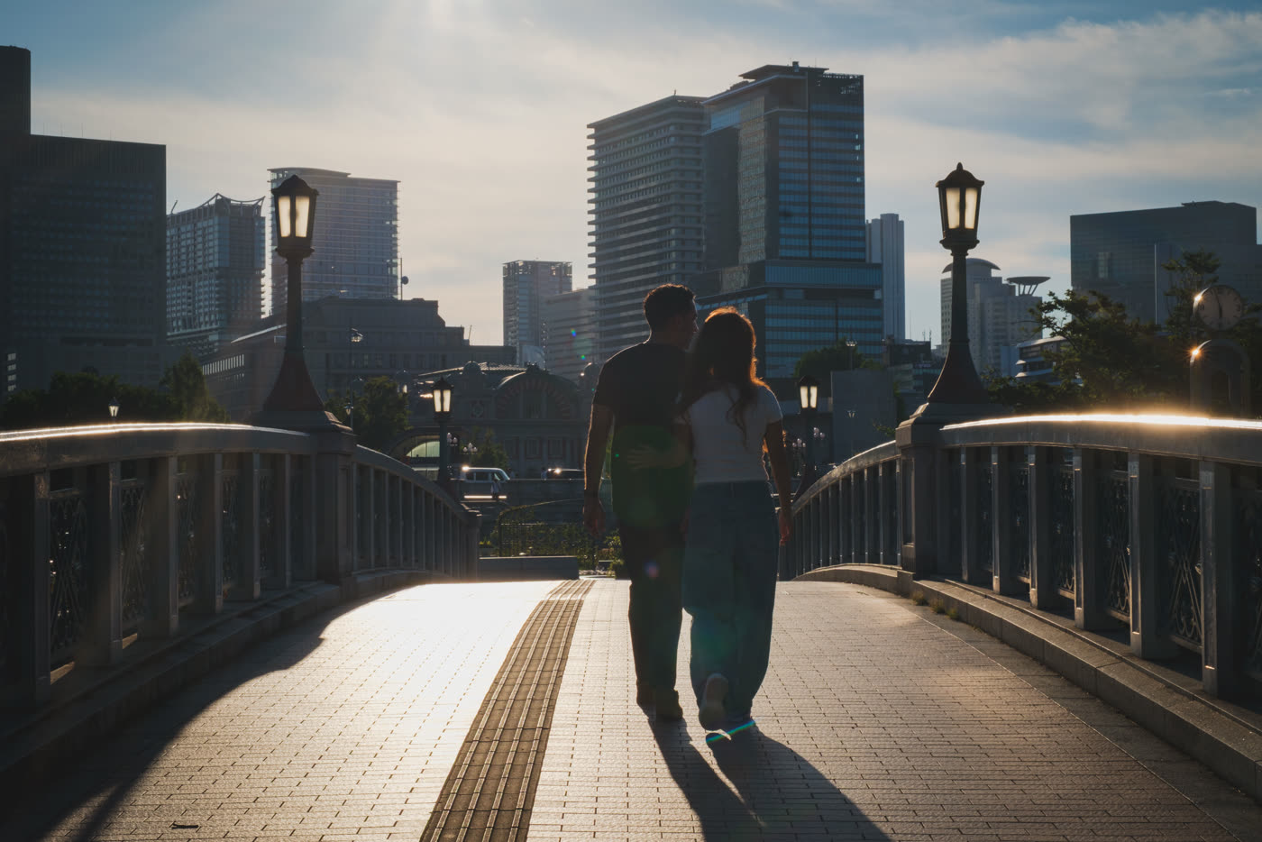 Ridou and Jiyun walking through a city at golden hour